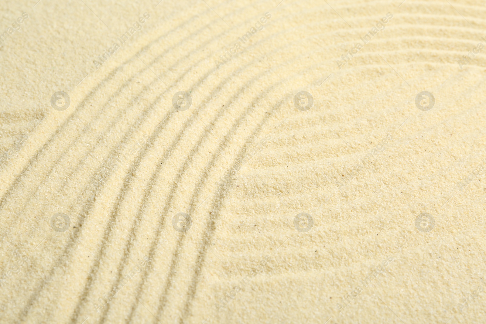 Photo of Zen rock garden. Wave pattern on beige sand