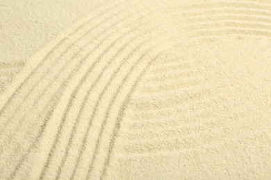 Photo of Zen rock garden. Wave pattern on beige sand