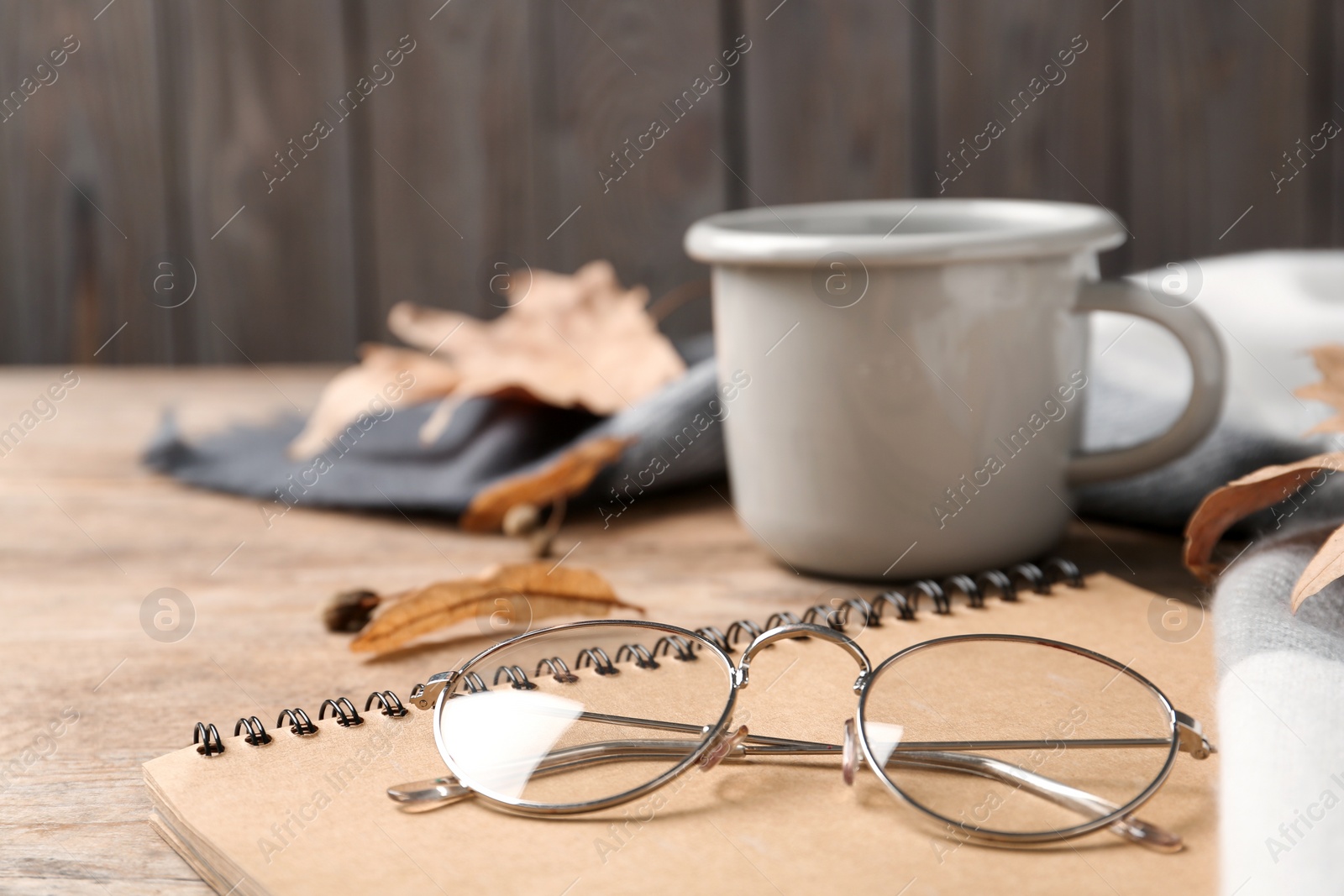 Photo of Notebook and glasses on wooden table, closeup. Space for text