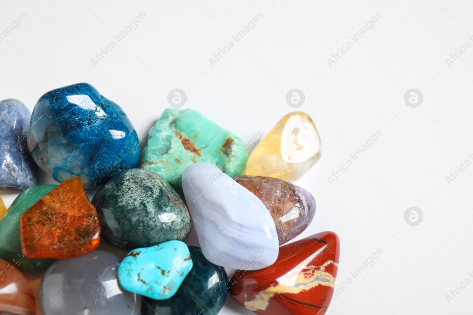 Photo of Different beautiful gemstones on white background, top view