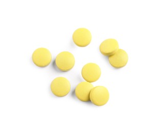 Photo of Many yellow pills isolated on white, top view