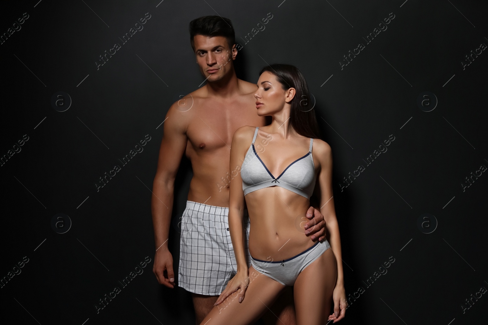 Image of Young couple wearing underwear on black background 