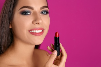 Photo of Portrait of beautiful woman with lipstick and space for text on color background. Stylish makeup