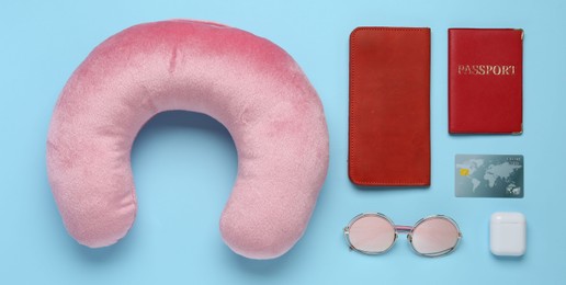 Photo of Flat lay composition with pink travel pillow on light blue background