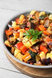 Photo of Delicious ratatouille in frying pan on grey wooden table, closeup