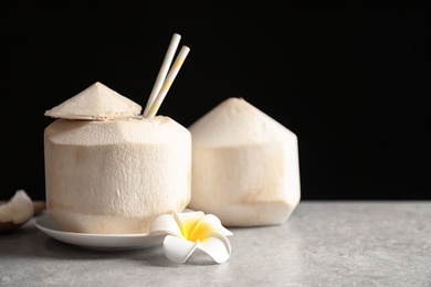 Photo of Fresh coconut drink in nut on table against black background