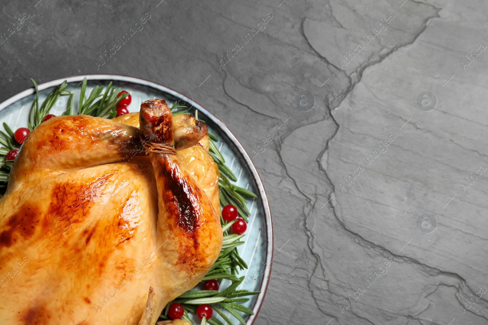 Photo of Delicious cooked turkey served on black table, top view with space for text. Thanksgiving Day celebration