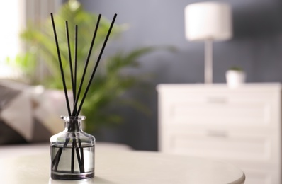 Aromatic reed air freshener on white table in room. Space for text