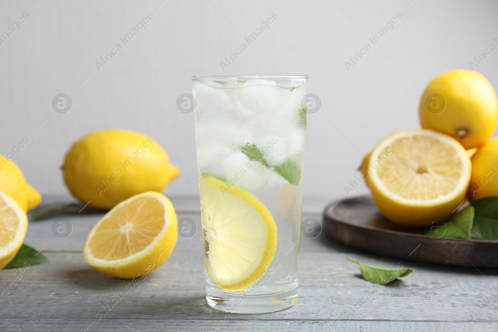 Photo of Cool freshly made lemonade and fruits on grey wooden table