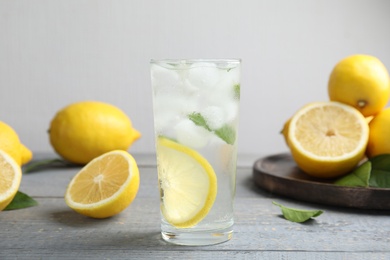 Cool freshly made lemonade and fruits on grey wooden table