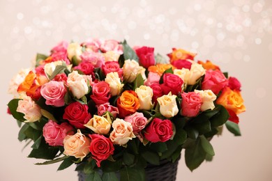 Bouquet of beautiful roses on beige background