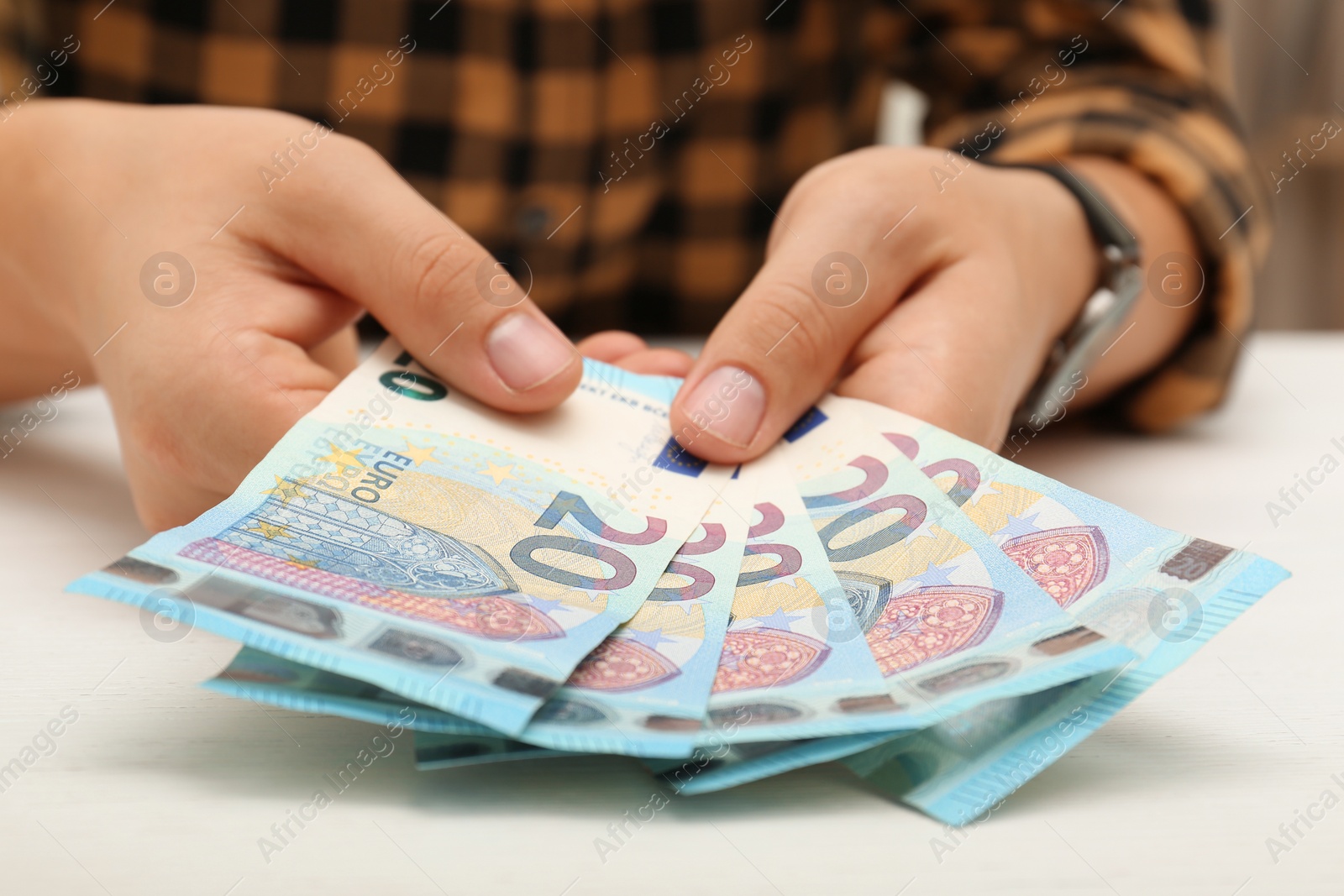 Photo of Man with Euro banknotes at table, closeup