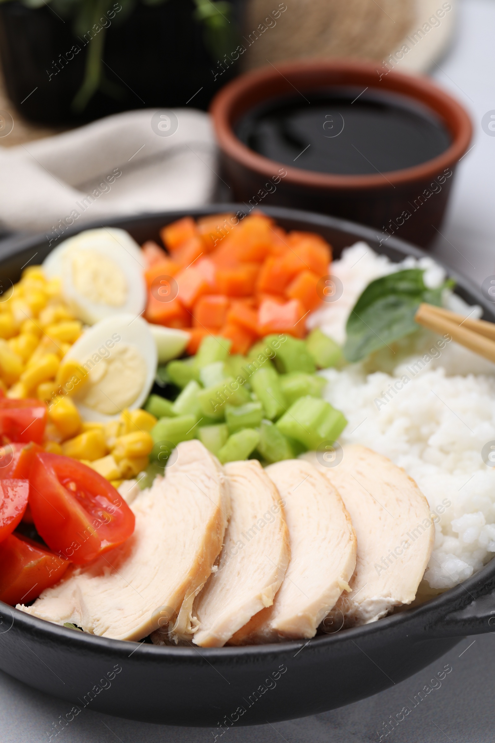 Photo of Delicious poke bowl with meat, egg, rice and vegetables on table, closeup