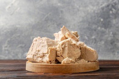 Photo of Pieces of compressed yeast on wooden table