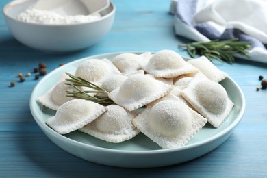 Photo of Homemade uncooked ravioli on blue wooden table