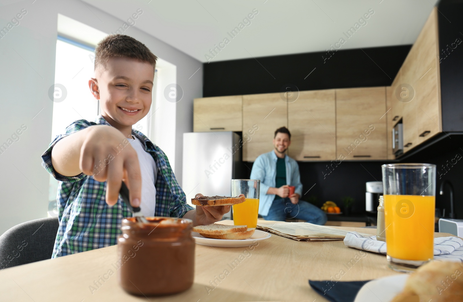 Photo of Dad and son having breakfast together in kitchen