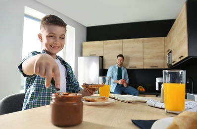 Dad and son having breakfast together in kitchen