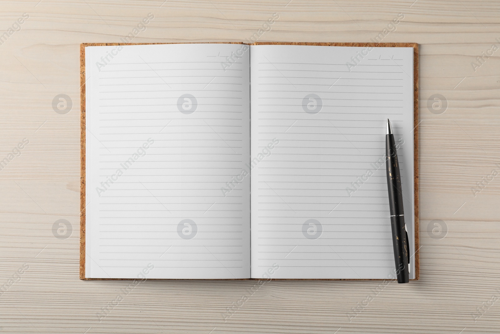 Photo of Empty notebook and pen on wooden table, top view