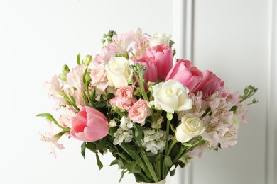 Photo of Beautiful bouquet of fresh flowers near white wall