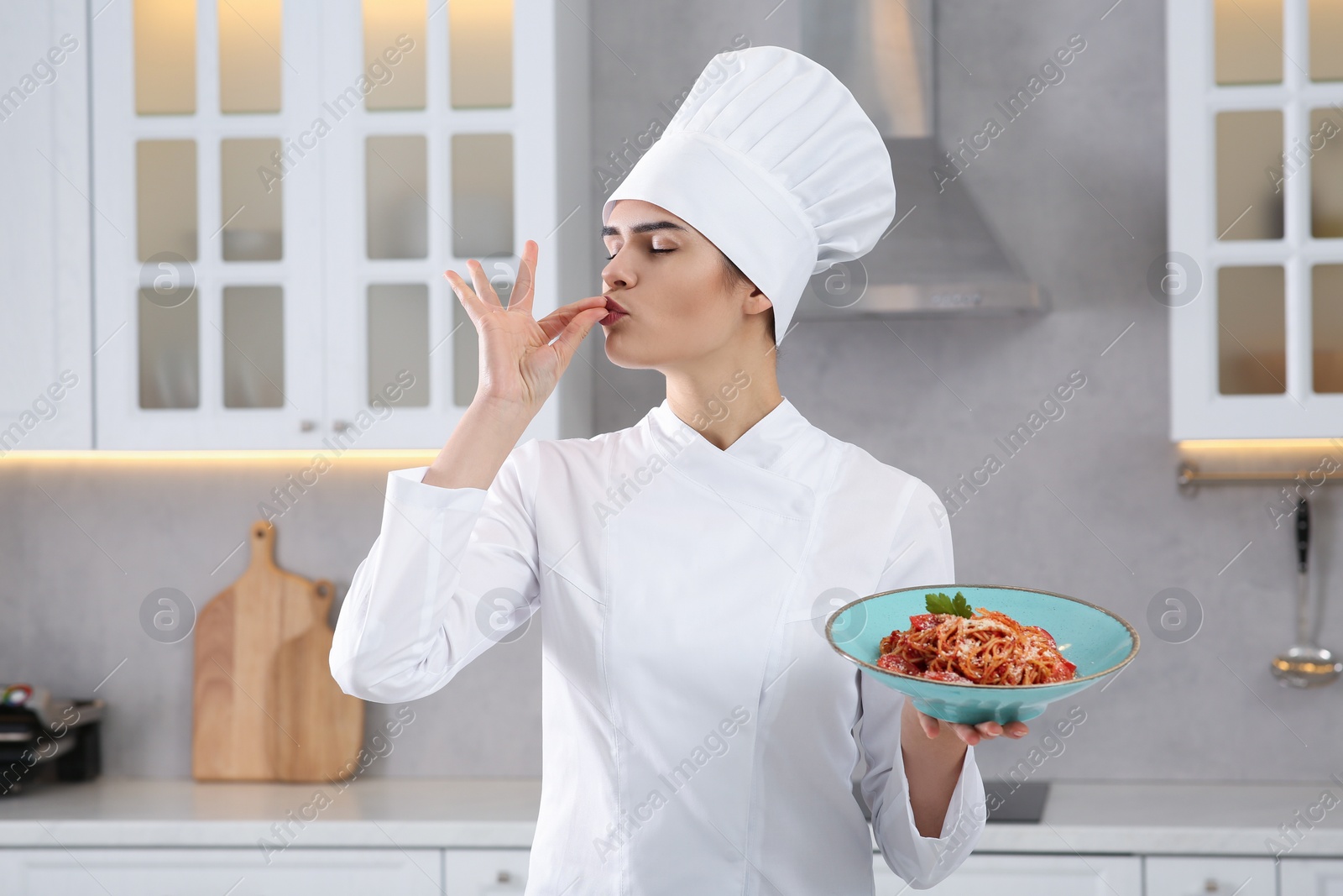 Photo of Professional chef with delicious spaghetti in kitchen