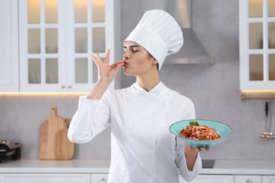 Photo of Professional chef with delicious spaghetti in kitchen