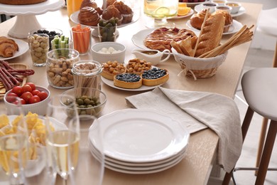 Photo of Variety of snacks on wooden table in buffet style indoors