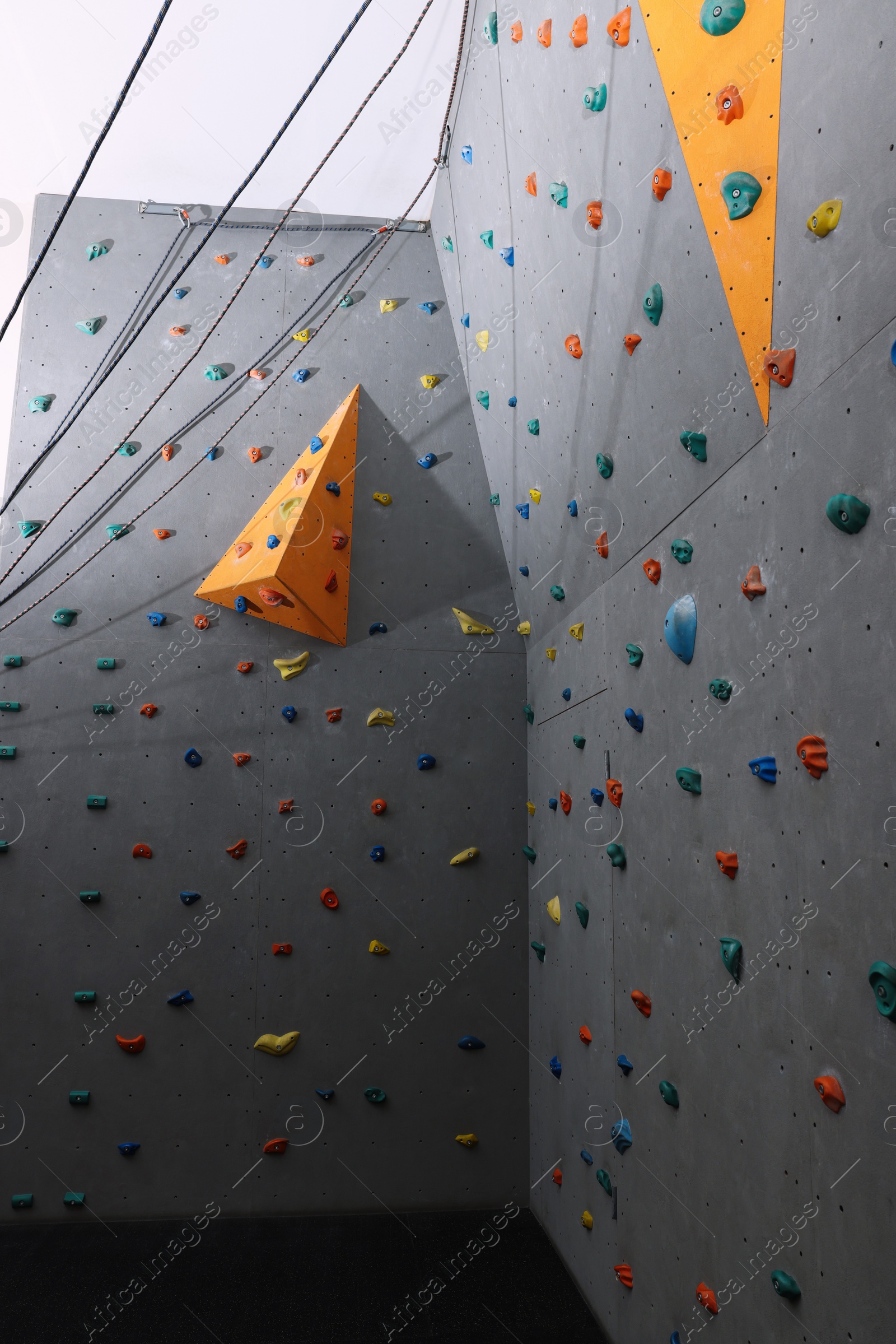 Photo of Climbing wall with holds in gym. Extreme sport