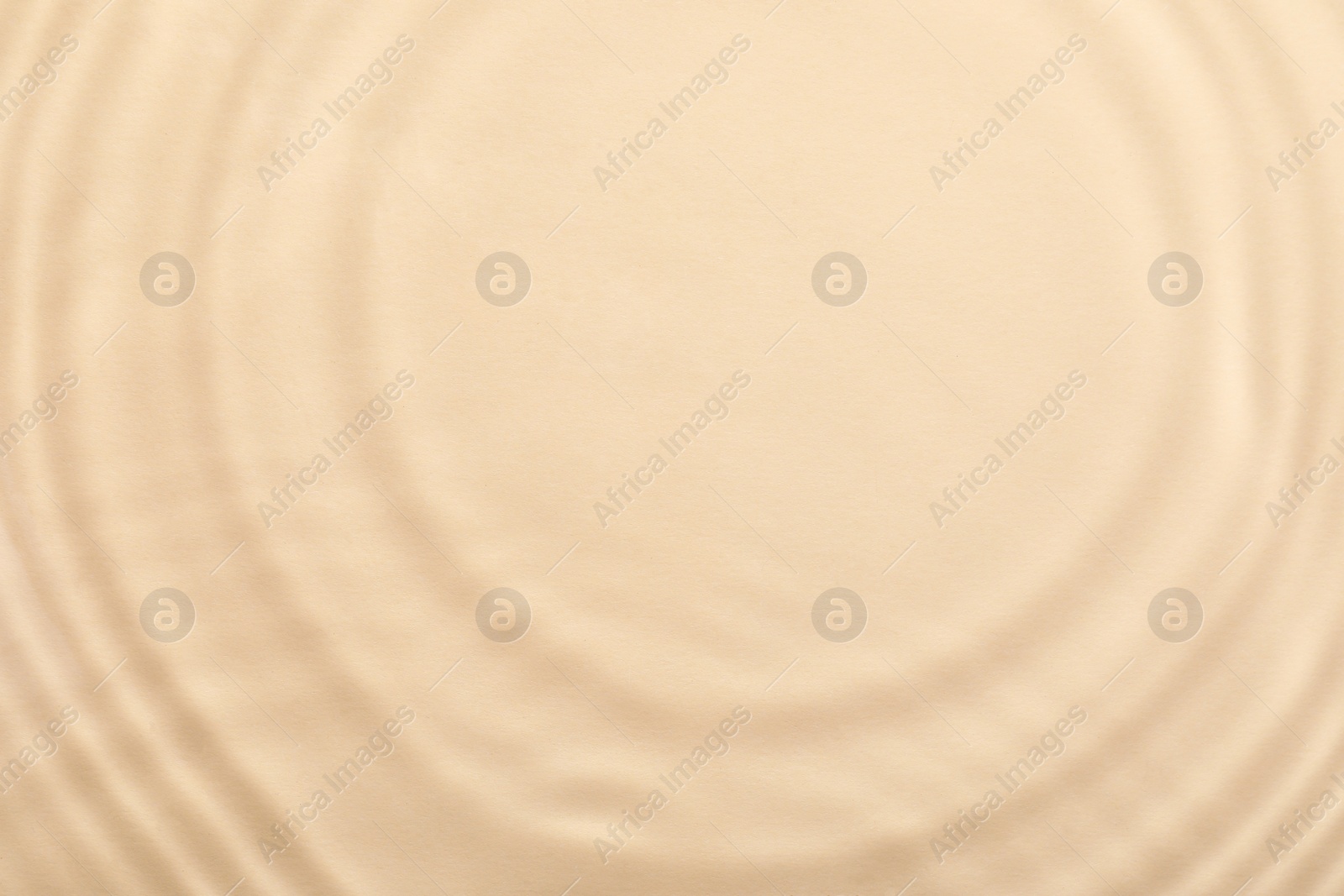 Photo of Closeup view of water with rippled surface on beige background