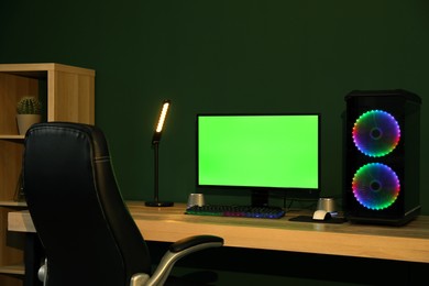 Photo of Modern computer and RGB keyboard on wooden table indoors. Mockup green screen