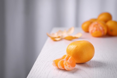 Photo of Delicious fresh tangerines on white wooden table