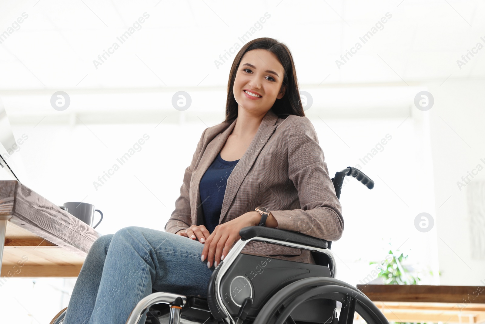 Photo of Portrait of young woman in wheelchair at workplace