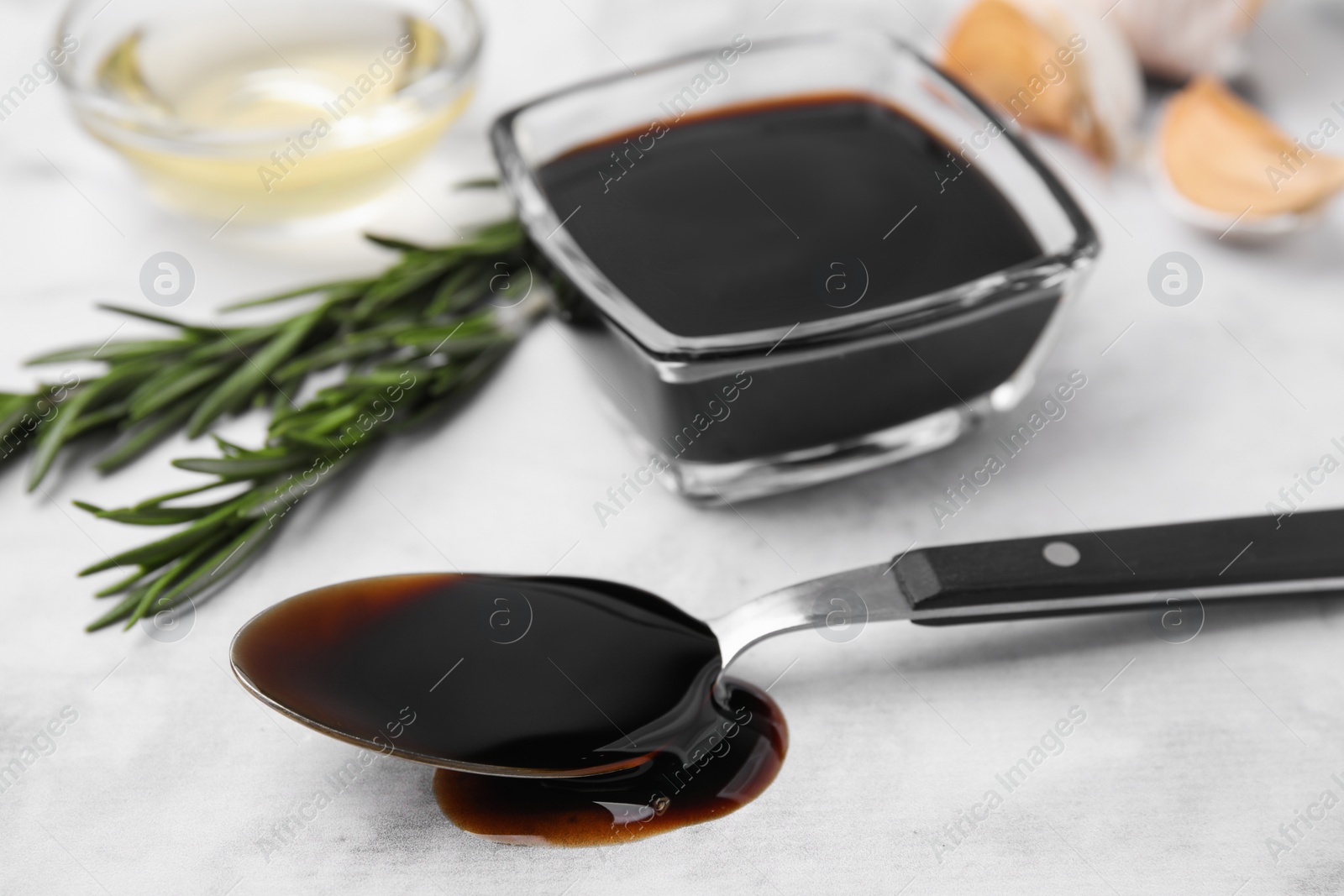 Photo of Organic balsamic vinegar and cooking ingredients on white table, closeup