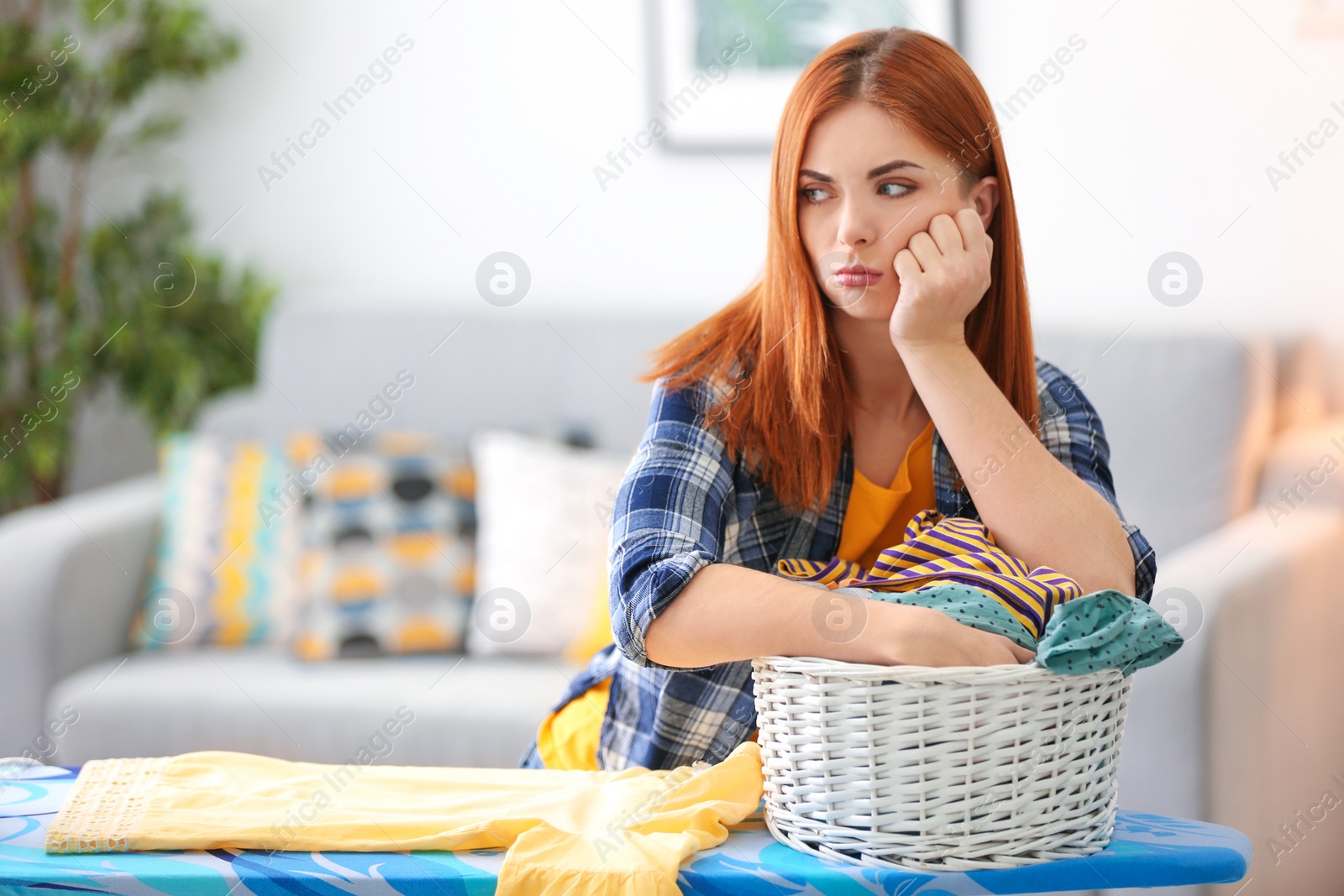 Photo of Tired housewife ironing clothes at home