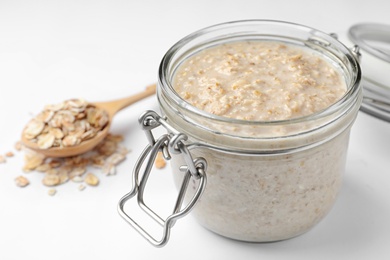 Photo of Handmade oatmeal face mask and ingredient on white background