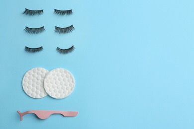 Photo of Flat lay composition with magnetic eyelashes and accessories on light blue background. Space for text