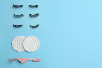 Flat lay composition with magnetic eyelashes and accessories on light blue background. Space for text