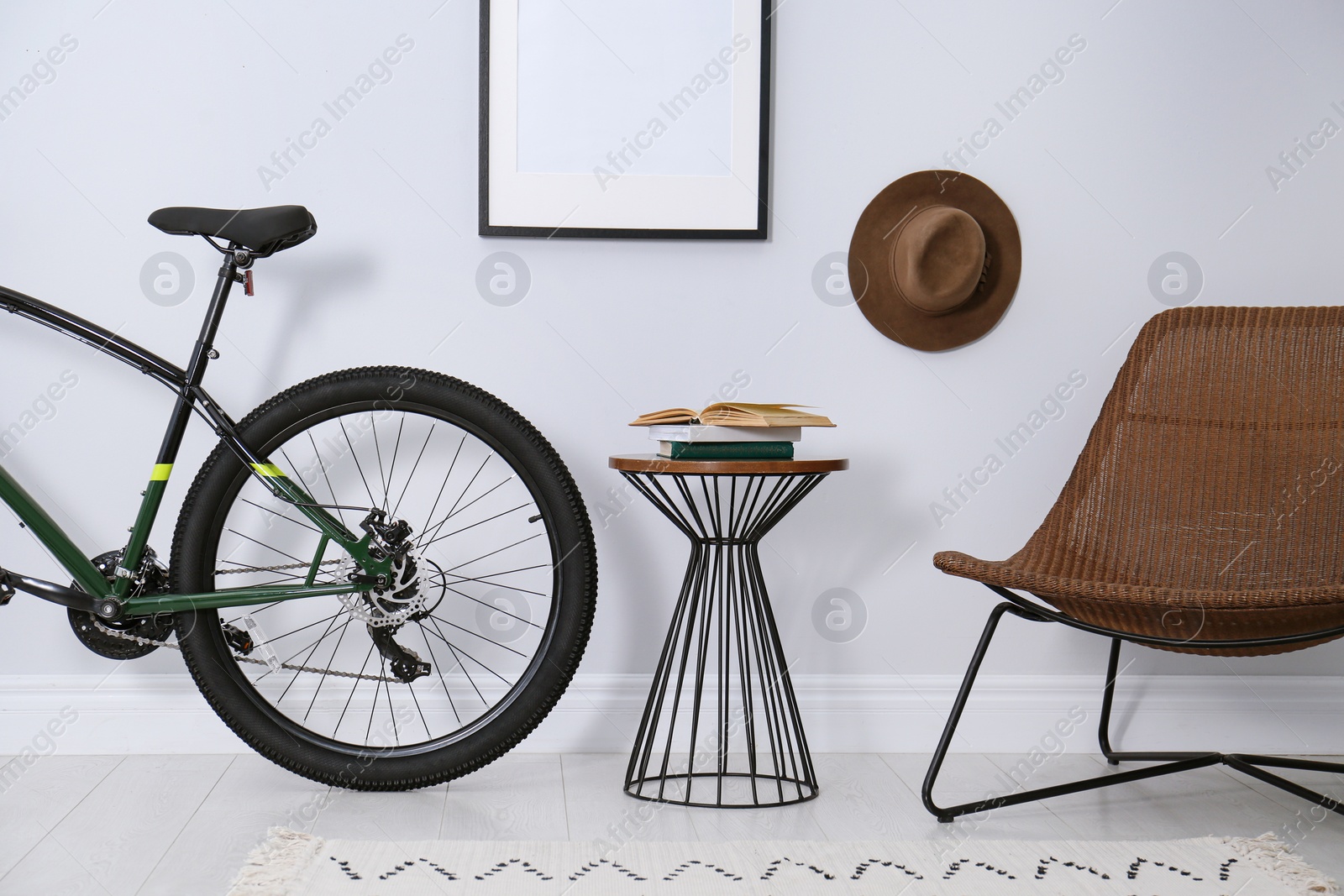 Photo of Modern bicycle and comfortable armchair in stylish living room interior