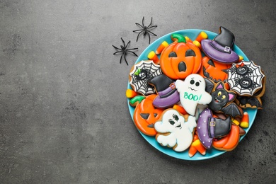 Photo of Tasty cookies and sweets for Halloween party on black table, flat lay. Space for text