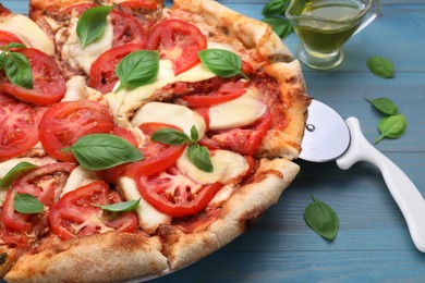 Photo of Delicious Caprese pizza on blue wooden table, closeup