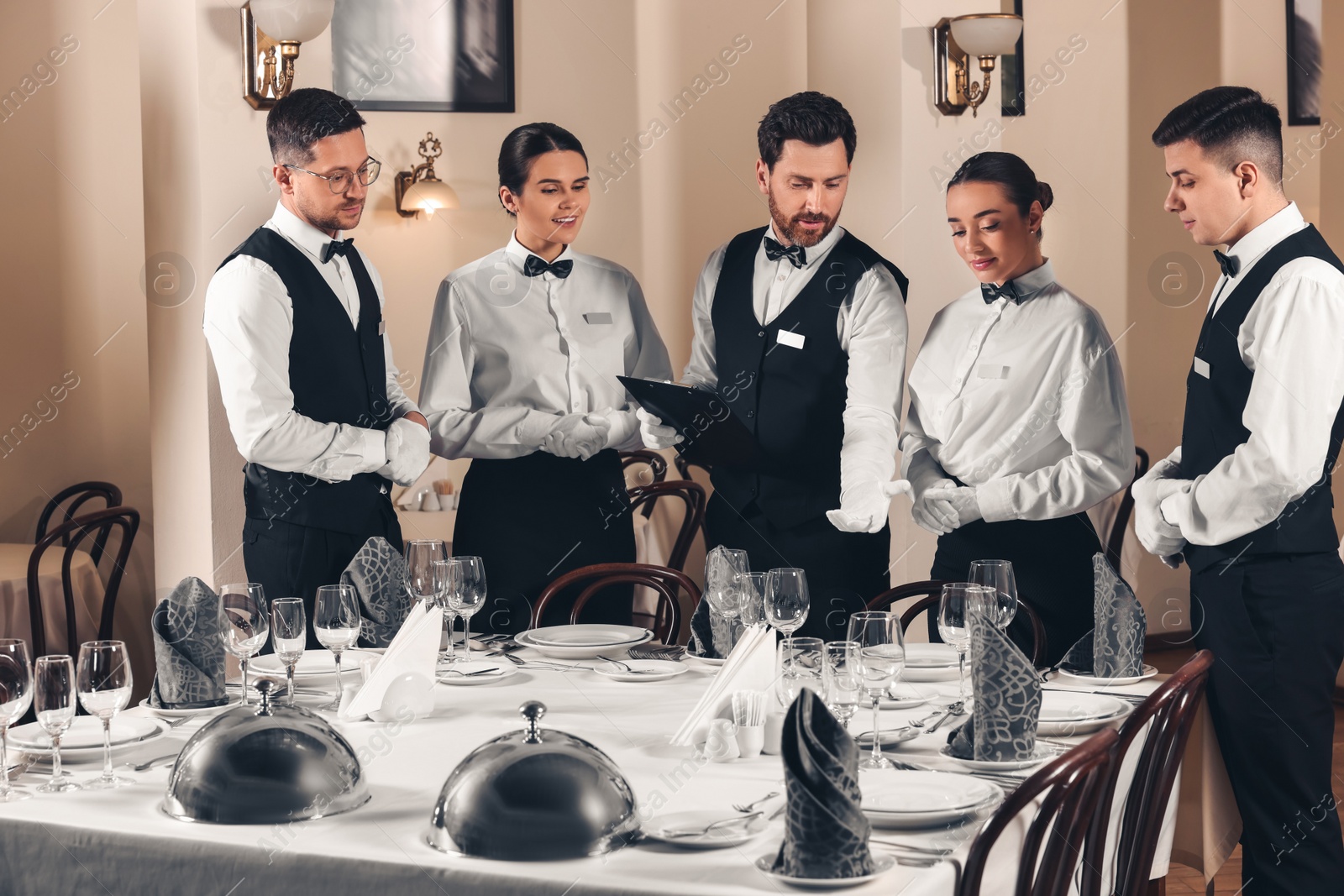 Photo of People setting table during professional butler courses in restaurant