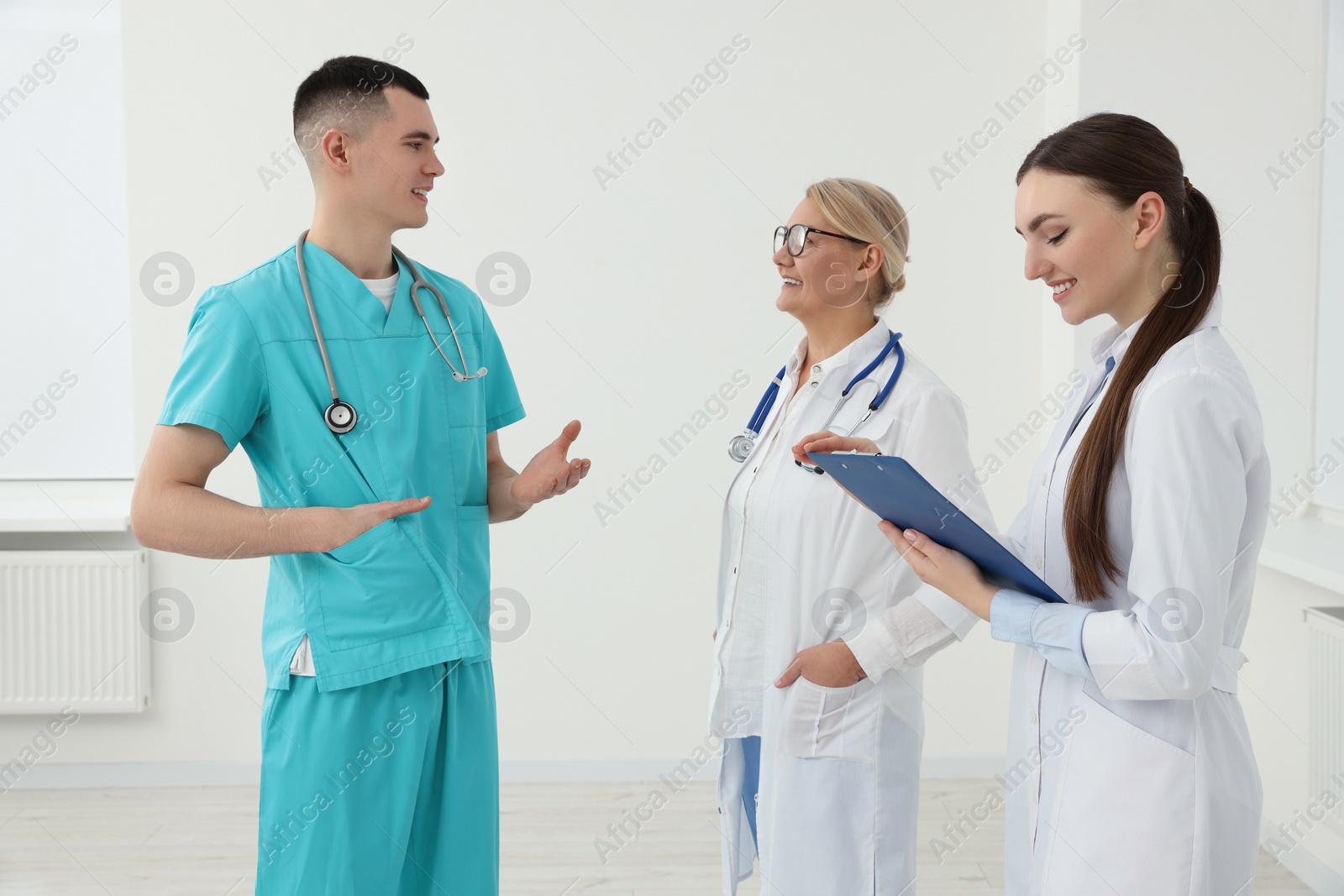 Photo of Medical doctors in uniforms having discussion in clinic