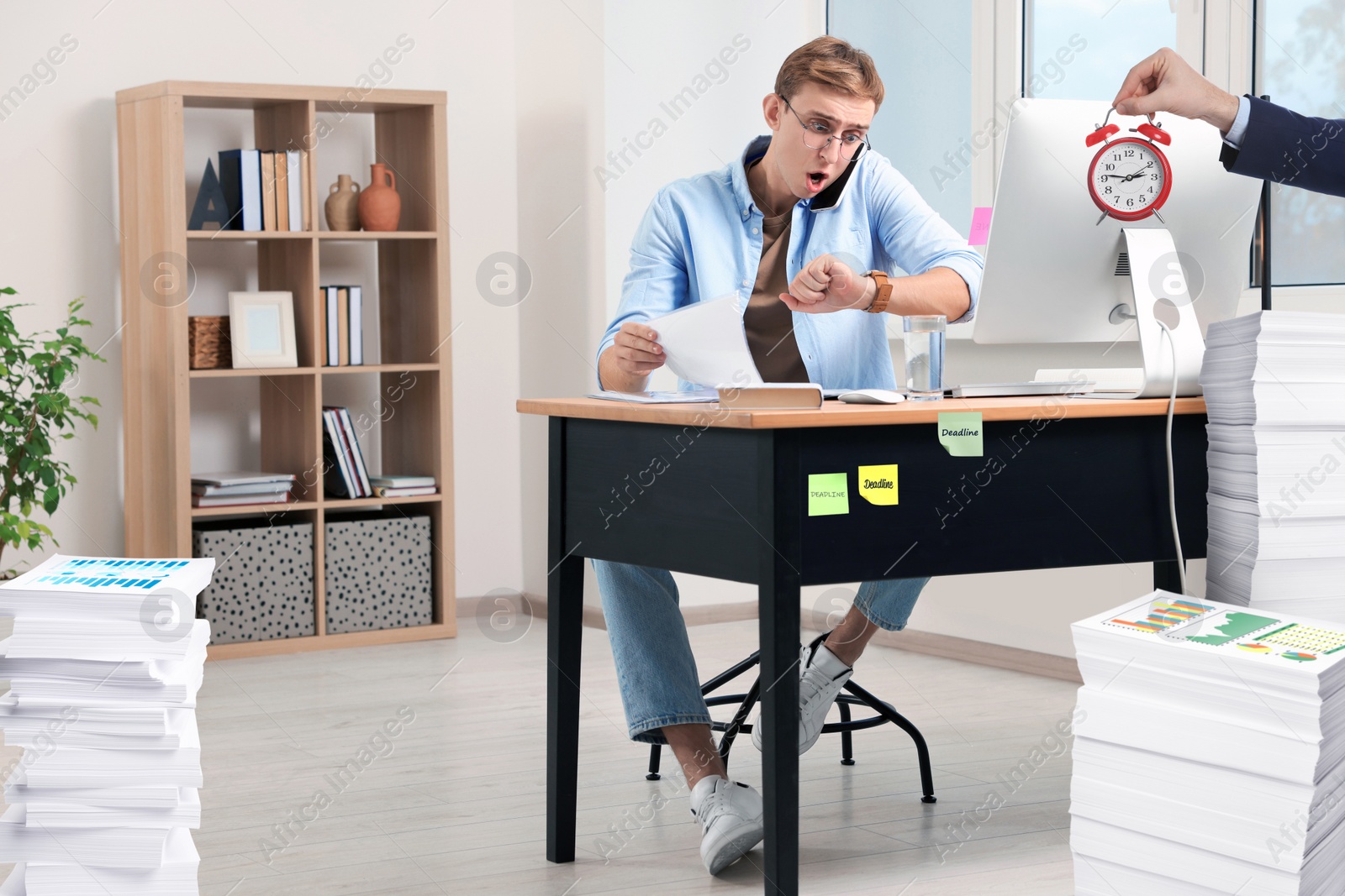 Image of Deadline concept. Boss holding alarm clock near overwhelmed worker at desk in office