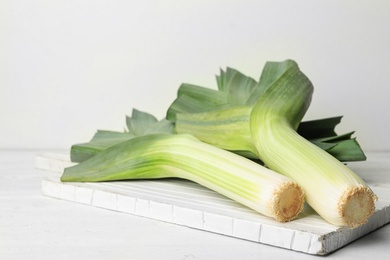 Fresh raw leeks on white wooden table. Ripe onion