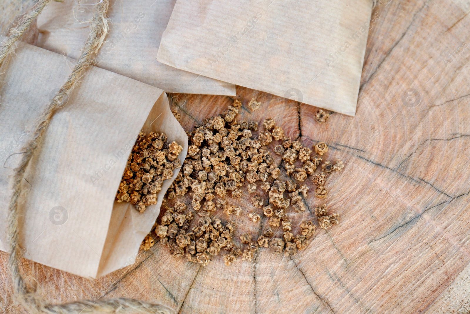 Photo of Paper bags with beet seeds on wooden background, flat lay. Vegetable planting