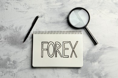Photo of Notebook with word Forex, magnifying glass and pen on light table, flat lay