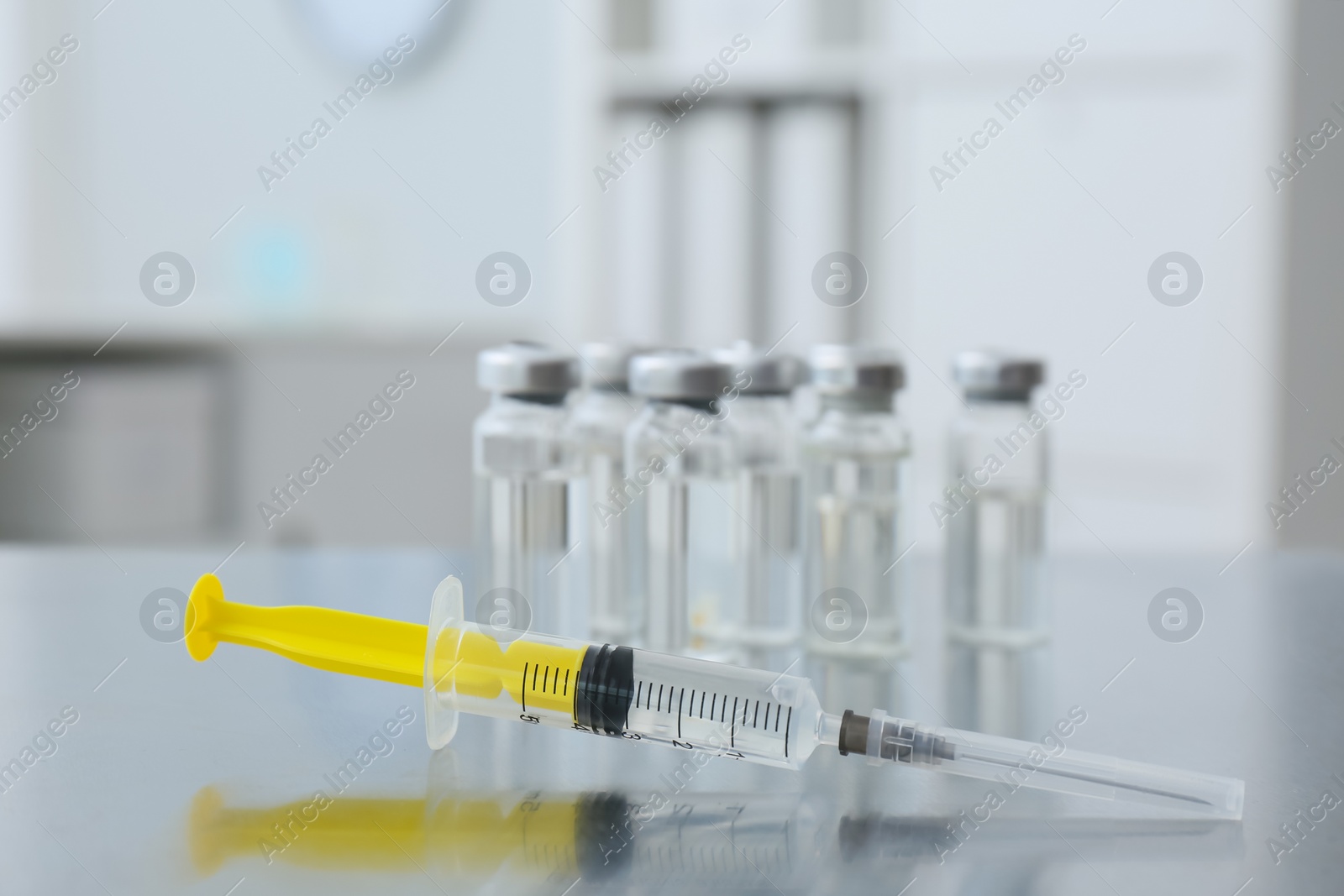 Photo of Syringe and vials with medicine on table indoors