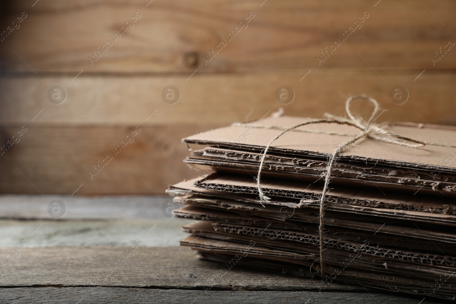 Photo of Stack of waste paper on wooden table, closeup. Space for text