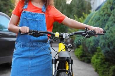 Young woman with bicycle on city street, closeup