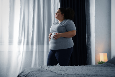 Overweight woman suffering from depression at home