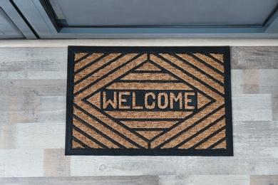 Photo of New clean mat with word WELCOME near entrance door, top view